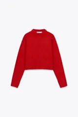 Jersey rojo de punto con cuello redondo y manga larga. Bajo con aberturas laterales.