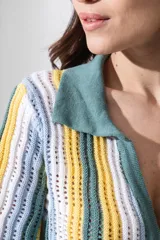 Vestido corto tejido calado a rayas horizontales en tonos naranja, amarillo y blanco, con cuello tipo polo y cierre frontal con botones.