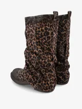 Bota de caña media confeccionada en gamuza con estampado animal print de leopardo. Presenta un diseño de silueta relajada con efecto fruncido, base plana y suela de goma resistente.