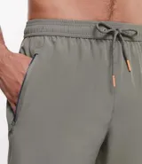 Bermuda deportiva negra sin estampa, con cintura elástica ajustable con cordón, y bolsillo lateral con cierre de cremallera en color contrastante.