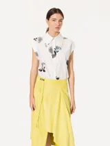Camisa blanca de poplin paper con estampado de limones, cartera oculta con botones de pasta al tono, pie de cuello con broche níquel y mangas japonesas.