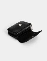 Billetera negra de cuerina con textura croco y tag metálico en relieve. Cierre con broche a presión.