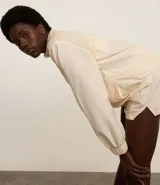 Campera deportiva femenina, modelo rompevientos, confeccionada en poliamida, con cuello alto y puños ajustados. Sin estampa, tiene cierre delantero con cremallera y recortes con hilo reflectante.