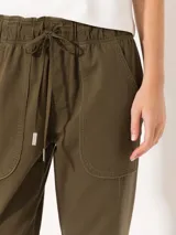 Pantalón babucha color verde militar, confeccionado en tejido de punto y plano. Tiene cintura elastizada con cordón ajustable y largo al tobillo.