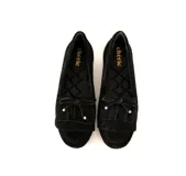 Mocasín de cuero gamuzado color negro, con flecos y lazo con herrajes metálicos dorados. Interior forrado en cuero y suela de goma flexible.