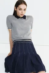 Remera gris de punto fino con cuello redondo y mangas cortas.
