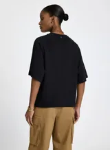 Remera negra de algodón con mangas cortas, cuello redondo y estampado frontal de un grupo de mujeres con diferentes estilos.
