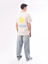Remera color beige con estampado pequeño en el pecho.
