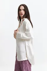 Camisa negra de manga larga confeccionada en tela satinada.