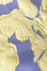 Top sin mangas color lila con estampado de flores amarillas.