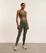 Top deportivo verde militar confeccionado en microfibra texturizada. Diseño con escote nadador en la espalda, copa y bies contrastante color amarillo.
