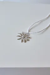 Collar con dije de acero quirúrgico hipoalergénico en forma de margarita plateada y tiento sailor color borgoña.