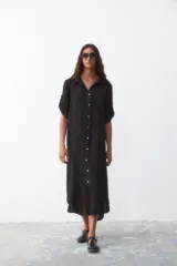 Vestido camisero midi negro de lino con botones blancos y mangas cortas con presilla.