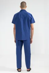 Camisa azul de manga corta confeccionada en algodón ligero con textura waffle. Presenta un corte cuadrado, bolsillo en el pecho y botones de coco con el logo de Polonio.