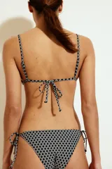 Top de bikini triangular con estampado geométrico en blanco y negro. Tiene tirantes finos ajustables y copas con relleno extraíble.