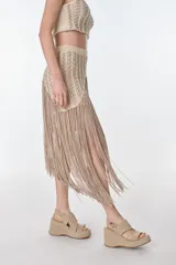 Falda midi color beige de tejido de punto con flecos.