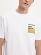 Remera blanca de algodón con cuello redondo y mangas cortas. Estampado en el frente con el logo de Calvin Klein Jeans y el año de fundación 1978, con efecto difuminado en tonos dorados.
