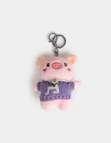 Llavero con forma de cerdito de peluche color rosa, con sweater tejido color lila y collar de perlas sintéticas.