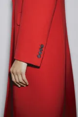 Abrigo rojo de lana con doble botonadura, cuello con solapa y bolsillos con solapa en la parte delantera.