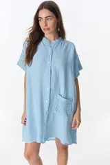 Vestido camisero celeste de lino con cuello mao, manga corta con detalle de calado y bolsillo de crochet.