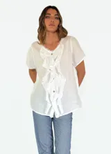Camisa blanca de lino y algodón con cuello en V y volados frontales.