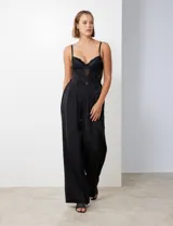 Pantalón palazzo de tiro alto color violeta, de satén. Tiene pretina delantera con pasadores, botón y cierre, pretina trasera elastizada y bolsillos verticales delanteros.