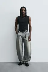 Pantalón de jean celeste con efecto lavado, corte holgado desde la cadera que se estrecha ligeramente en el bajo, tiro medio, cinco bolsillos y cierre frontal con cremallera y botón.