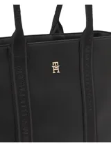 Bolso tipo tote negro de Tommy Hilfiger con cierre de cremallera, doble asa superior con inscripción de la marca y logo dorado en el frente.
