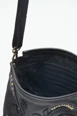 Cartera bandolera verde de cuero vacuno con bordado de flores y tachas doradas y plateadas. Tiene cierre metálico superior, forro de algodón, división interna, bolsillo y tarjetero. La correa es regulable.