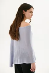 Poncho color beige de tejido de punto con cuello asimétrico.