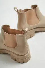 Botas de lluvia color beige, de goma con elástico en los costados y suela track.
