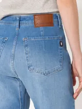 Pantalón de jean azul claro, de corte recto y tiro medio, con detalle de costuras horizontales en las rodillas y terminación desflecada.