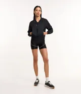 Campera rompevientos deportiva color blanco, confeccionada en poliamida, con capucha, cierre delantero en cremallera, tirador gomoso y puños ajustados.