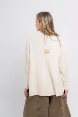 Sweater color crudo de corte holgado, con cuello redondo y terminaciones acanaladas en puños y ruedo.