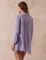 Camisa color beige claro, de corte recto y mangas 3/4 con botón para sujetar.