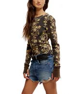 Blusa térmica color crema con estampado floral en tonos rojos y verdes, de mangas largas con puños acampanados.