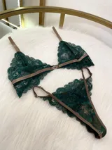 Conjunto de encaje verde suave, compuesto por bralette y tanga regulable con broche frontal.