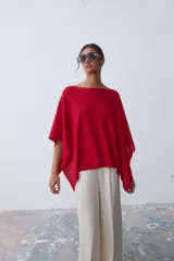 Poncho tejido de punto color rojo con cuello bote y corte asimétrico.