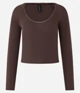 Blusa manga larga color marrón confeccionada en rib con detalle de encaje en el escote. Escote en U.