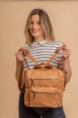 Mochila mediana color marrón de símil cuero con asa superior, dos compartimientos con cierre y bolsillos frontales.