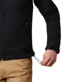 Chaqueta softshell Columbia para hombre, color negro, con cierre frontal, cuello alto y logo de la marca en blanco en el pecho. Presenta bolsillos laterales y uno en el pecho con cierre.