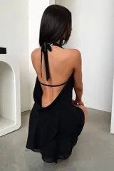 Vestido corto color marrón chocolate, con escote drapeado profundo, tirantes finos que se anudan en la espalda y falda con volados.