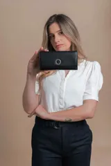 Billetera larga de símil cuero color negro con solapa y aro metálico. Tiene reparticiones con cierre, compartimentos con tarjeteros y bolsillos, monedero con cierre y solapa trasera con botón.