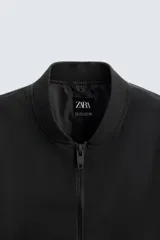 Cazadora bomber ligera gris confeccionada en tejido técnico. Cuello y puños en rib elástico, manga larga, bolsillos de vivo en cadera y bolsillo interior. Cierre frontal con cremallera.