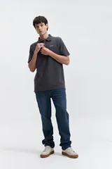 Chomba gris con textura tipo waffle, corte regular y logo bordado en el pecho.