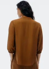 Blusa color verde claro, de mangas 3/4 con elástico en los puños, escote en V con botones y corte holgado.