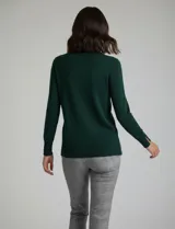 Polera de punto fino marca Nienty, color blanco, con cuello alto volcado y mangas largas con detalle de tajo en los puños.