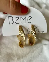 Aros dorados con forma de gota y textura irregular.