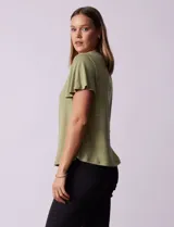Remera verde con tejido melange, escote en V y aplique de crochet en la parte delantera.