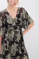 Vestido largo negro con estampado floral dorado en lurex, escote en V cruzado, mangas al codo, cintura elastizada con lazo y viso al tono con breteles regulables y puntilla en el escote.